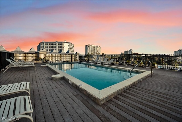 pool at dusk with a wooden deck