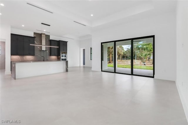 unfurnished living room with sink and a high ceiling