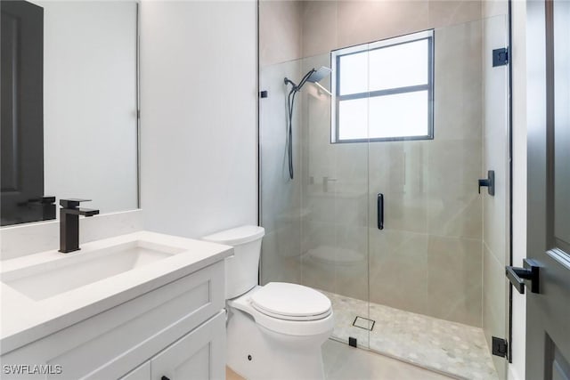 bathroom with walk in shower, vanity, and toilet