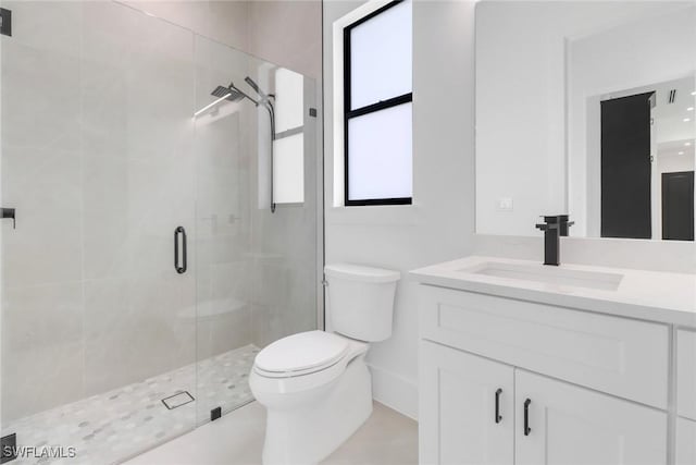 bathroom with walk in shower, vanity, and toilet