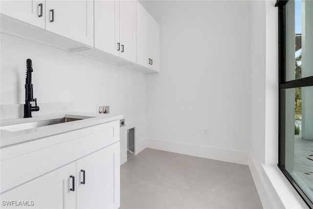 clothes washing area with electric dryer hookup, sink, cabinets, and washer hookup