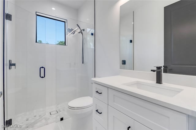 bathroom with vanity, a shower with shower door, and toilet