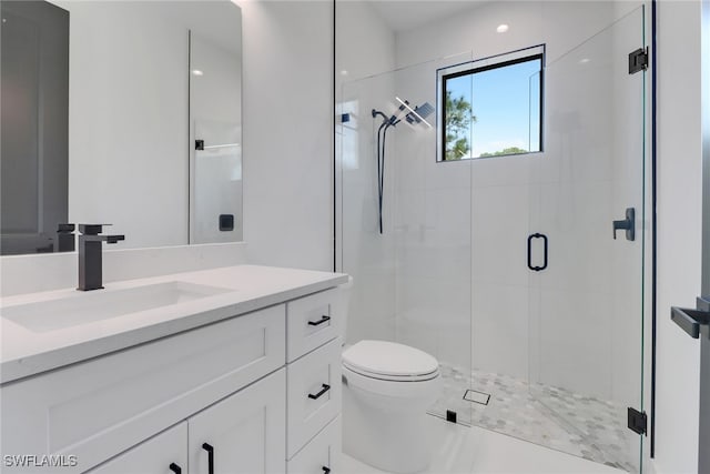 bathroom with a shower with door, vanity, and toilet