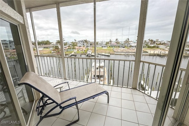 sunroom featuring a water view