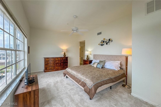 carpeted bedroom featuring ceiling fan and multiple windows