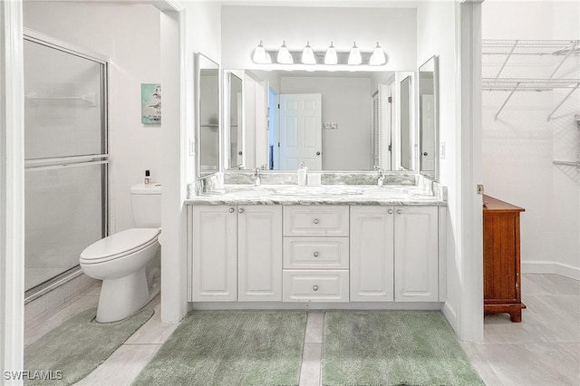 bathroom featuring tile patterned flooring, vanity, an enclosed shower, and toilet