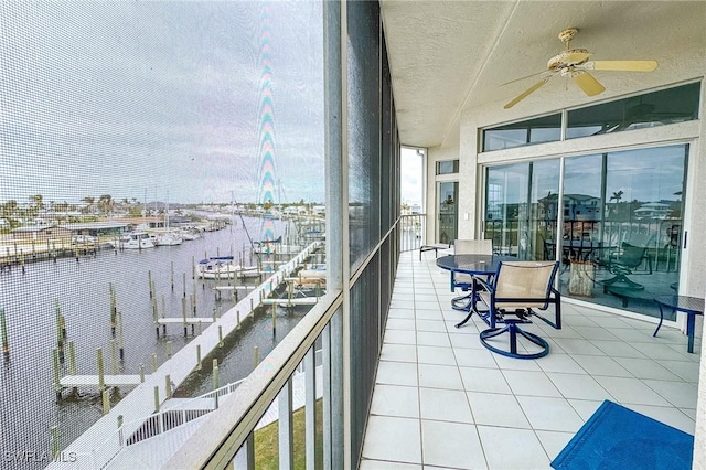 balcony with a water view and ceiling fan