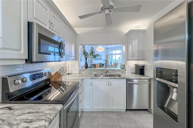 kitchen with decorative backsplash, appliances with stainless steel finishes, white cabinetry, and sink