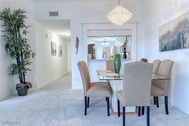 carpeted dining area featuring a chandelier