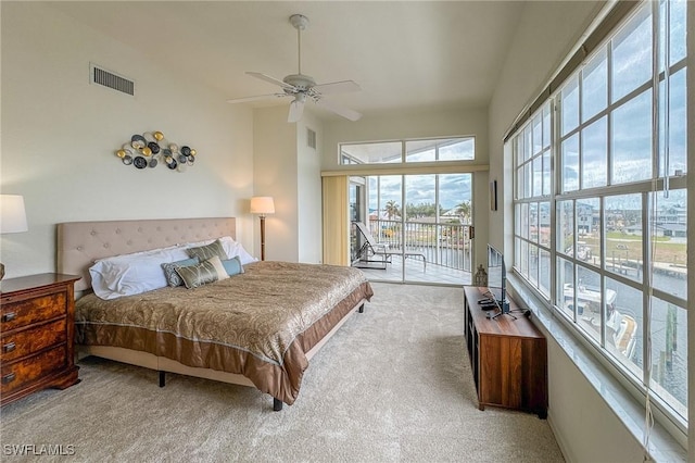 bedroom featuring access to exterior, ceiling fan, a towering ceiling, and light carpet