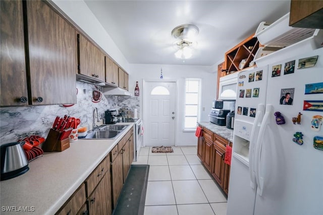 kitchen featuring sink, white refrigerator with ice dispenser, electric stove, decorative backsplash, and light tile patterned flooring