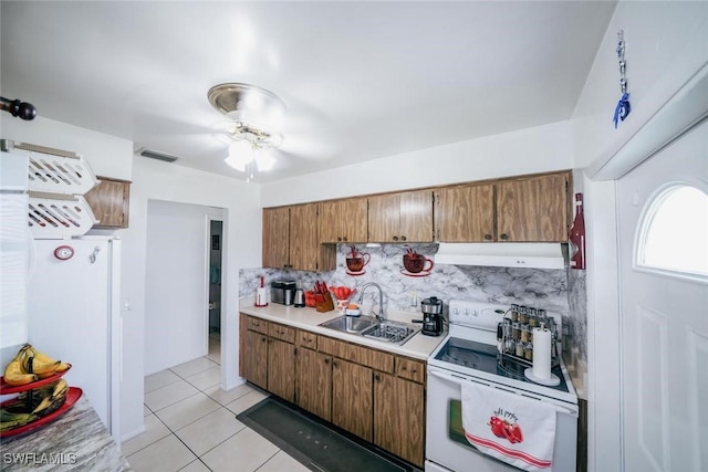 kitchen featuring decorative backsplash, white appliances, ceiling fan, sink, and light tile patterned floors