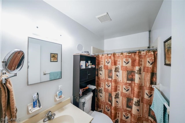 bathroom featuring a shower with shower curtain, vanity, and toilet