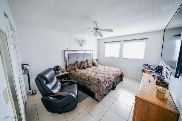 tiled bedroom featuring a textured ceiling and ceiling fan