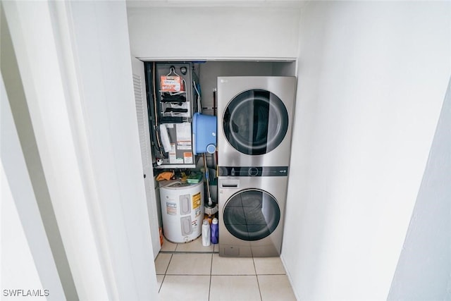 laundry area with stacked washer / dryer, electric water heater, and light tile patterned floors