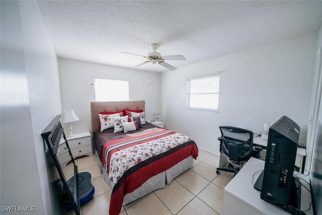 bedroom with ceiling fan, light tile patterned flooring, and a textured ceiling