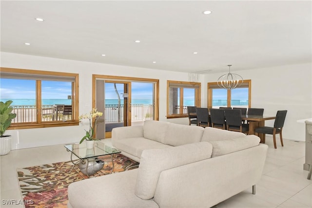 living room featuring a water view, an inviting chandelier, and a healthy amount of sunlight