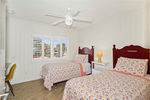 bedroom featuring ceiling fan, crown molding, and light hardwood / wood-style flooring