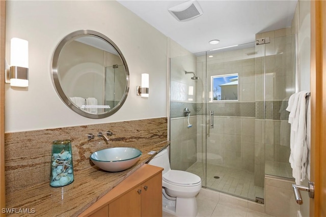 bathroom with toilet, vanity, tile patterned floors, and a shower with door