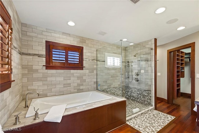 bathroom featuring hardwood / wood-style floors and plus walk in shower