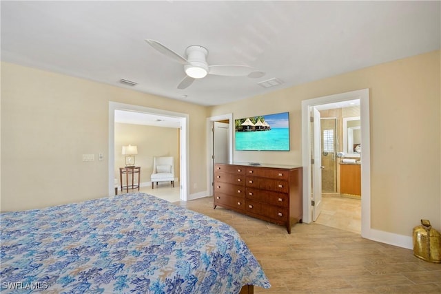 bedroom with ensuite bath, ceiling fan, and light hardwood / wood-style flooring