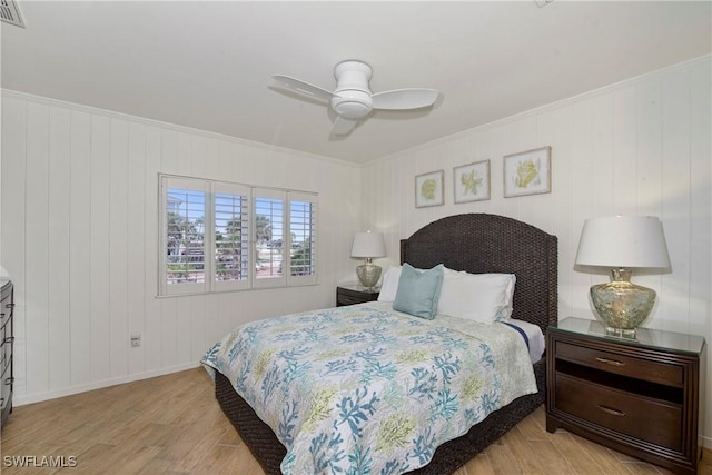 bedroom with ceiling fan, crown molding, and light hardwood / wood-style floors