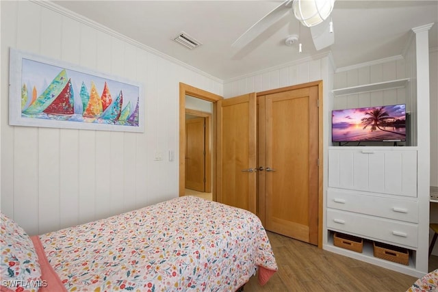 bedroom with hardwood / wood-style flooring, ceiling fan, and crown molding