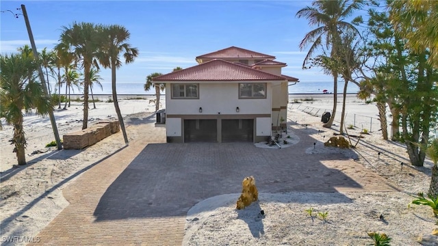 exterior space featuring a water view, a garage, and cooling unit