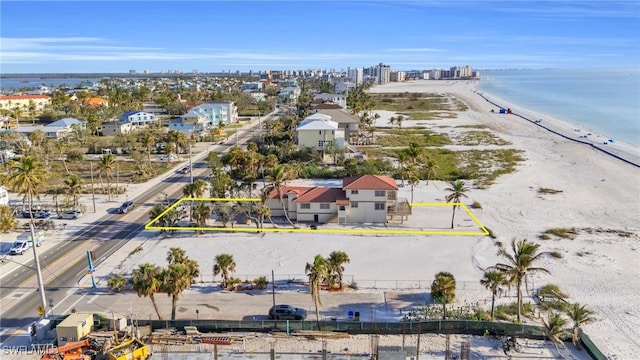 bird's eye view featuring a water view and a beach view