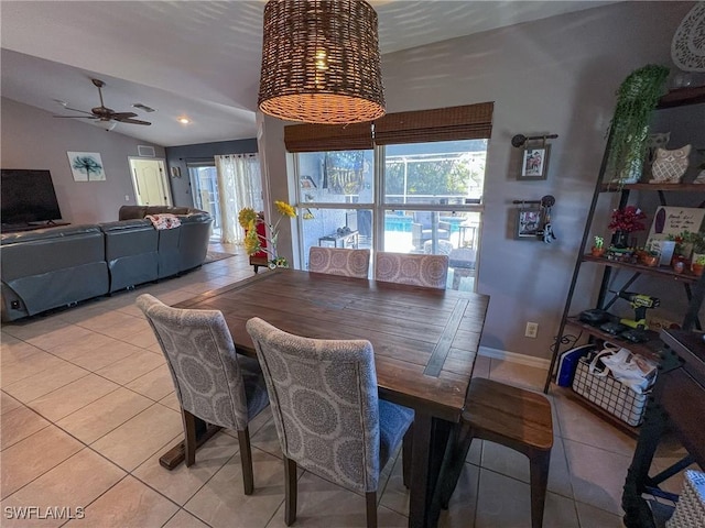 tiled dining area with ceiling fan and lofted ceiling