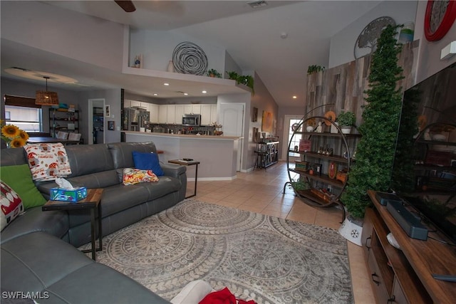 tiled living room with ceiling fan and high vaulted ceiling