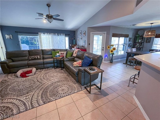 tiled living room featuring ceiling fan, lofted ceiling, and a wealth of natural light