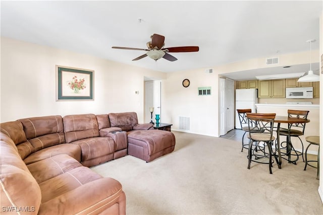 living room with ceiling fan and light colored carpet