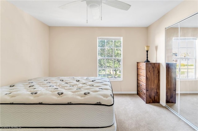 bedroom featuring a closet, ceiling fan, and light colored carpet