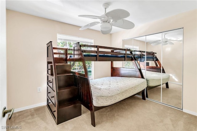 bedroom featuring light carpet, a closet, and ceiling fan