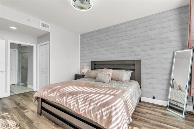 bedroom featuring hardwood / wood-style floors and wood walls