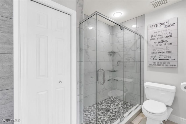 bathroom featuring toilet and an enclosed shower