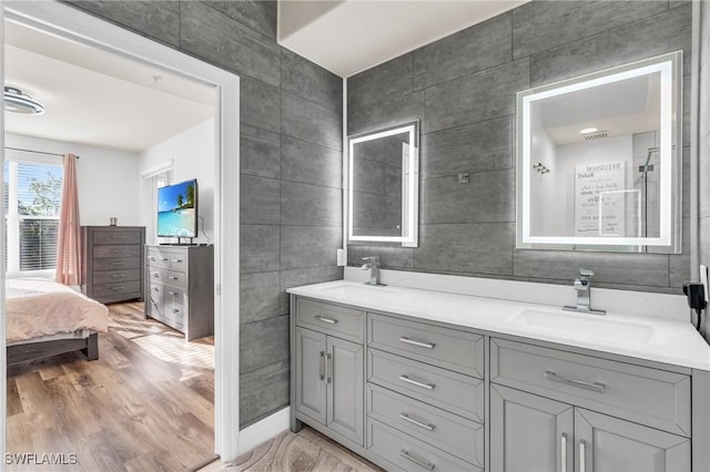 bathroom featuring vanity, wood-type flooring, and tile walls