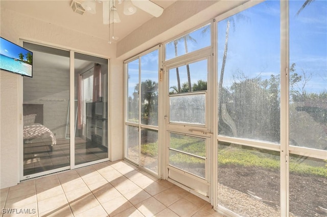 unfurnished sunroom with ceiling fan