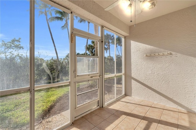 unfurnished sunroom with ceiling fan