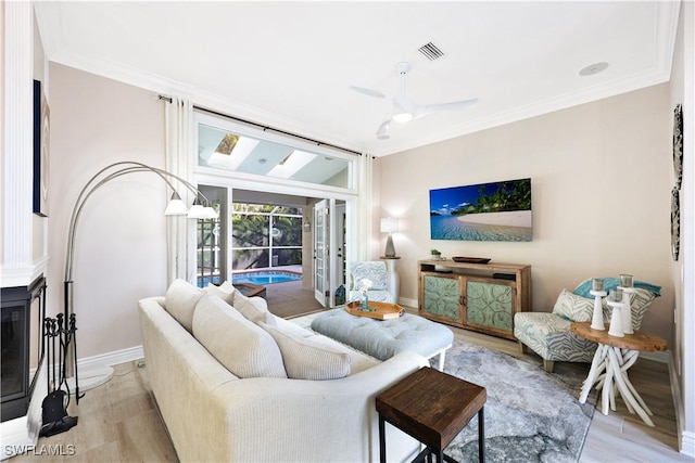 living room featuring ceiling fan, a fireplace, and light hardwood / wood-style floors