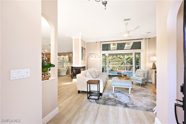 living room with ceiling fan and ornamental molding