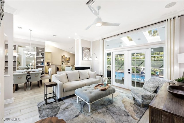 living room featuring ceiling fan, ornamental molding, lofted ceiling, and french doors