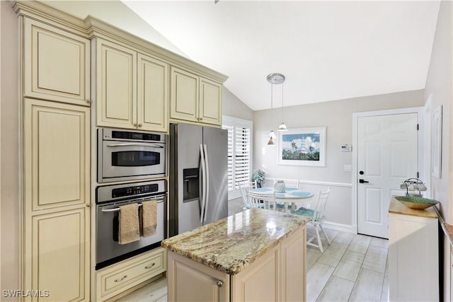 kitchen with light stone countertops, lofted ceiling, stainless steel refrigerator with ice dispenser, hanging light fixtures, and cream cabinets