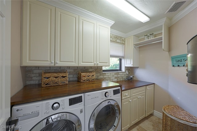 washroom with cabinets, ornamental molding, and independent washer and dryer