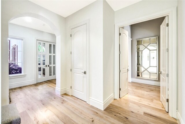 corridor featuring french doors and light hardwood / wood-style flooring