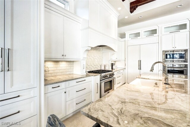 kitchen with white cabinets, light stone counters, and appliances with stainless steel finishes