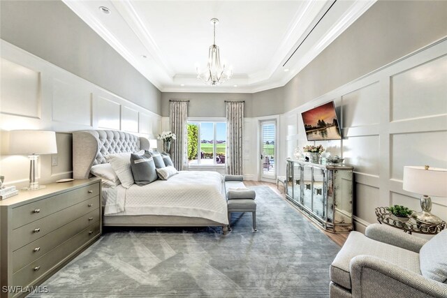 bedroom with a raised ceiling, crown molding, access to outside, and an inviting chandelier