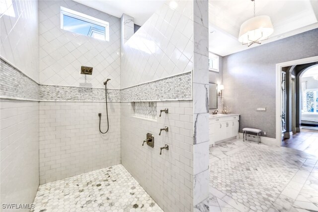 bathroom with a tile shower, plenty of natural light, and vanity