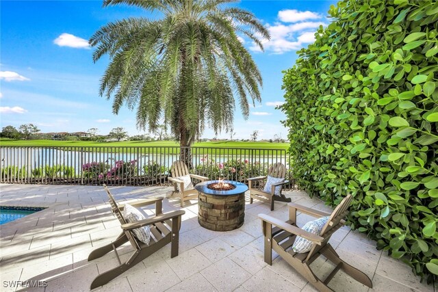 view of patio with a water view and an outdoor fire pit